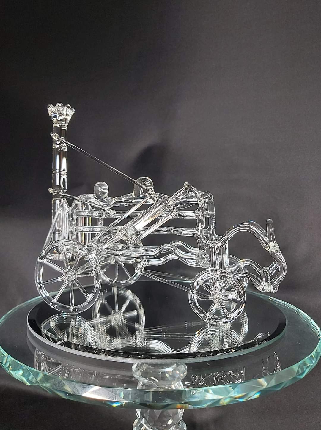 Glass horse and carriage sculpture on a mirrored stand